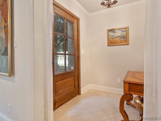 doorway featuring crown molding, light tile patterned floors, and baseboards