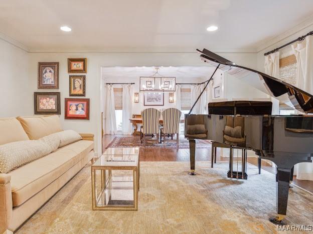 interior space featuring recessed lighting, a notable chandelier, ornamental molding, and wood finished floors