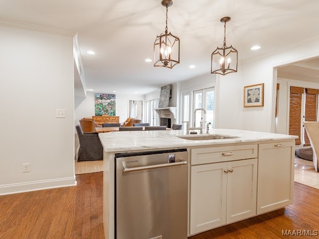 kitchen with dark hardwood / wood-style floors, sink, an island with sink, light stone countertops, and stainless steel dishwasher