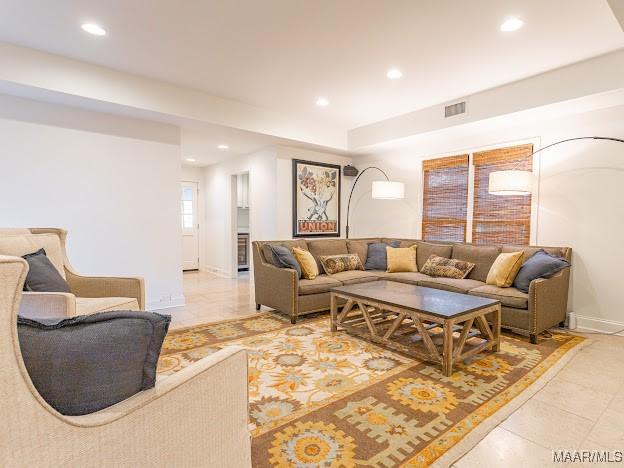 living area with recessed lighting, light tile patterned floors, visible vents, and baseboards