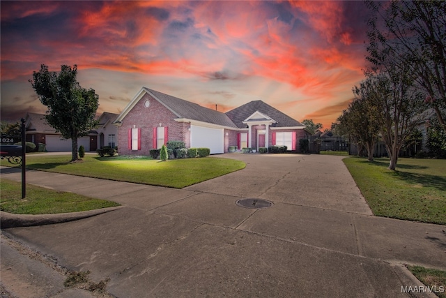 single story home featuring a garage and a yard