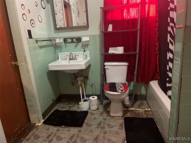 full bathroom with shower / bath combo with shower curtain, tile walls, sink, and toilet