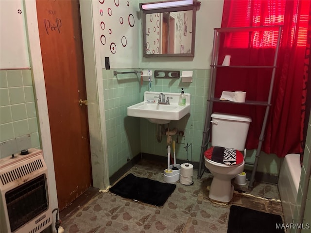 bathroom featuring heating unit, tile walls, sink, and toilet