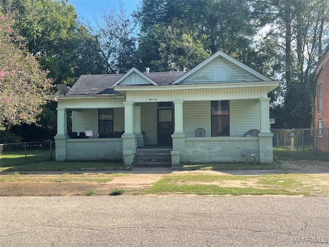 bungalow-style house featuring a porch, roof with shingles, and fence
