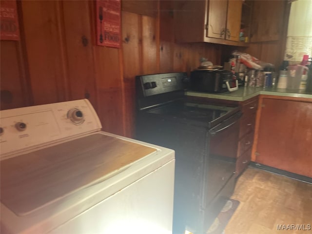 washroom with washer / clothes dryer and wooden walls