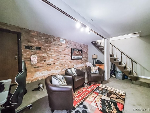 carpeted living room featuring brick wall