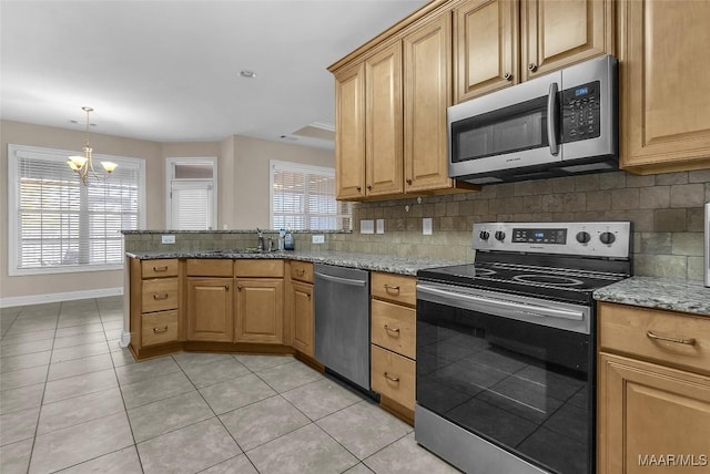 kitchen featuring decorative backsplash, light tile patterned floors, a notable chandelier, light stone counters, and stainless steel appliances