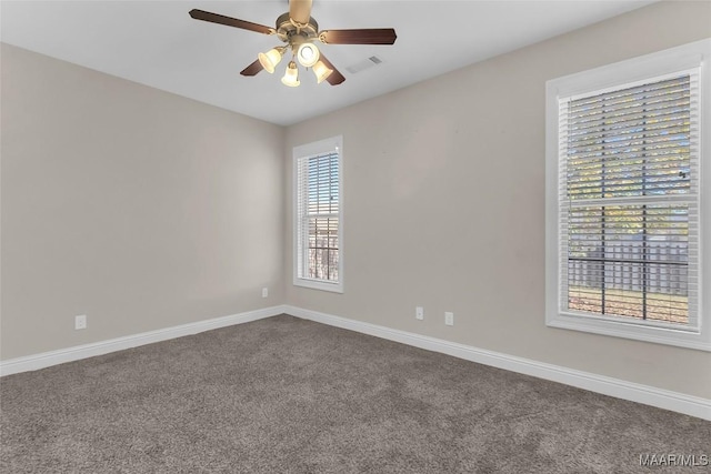 carpeted spare room with a wealth of natural light and ceiling fan