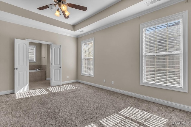 unfurnished bedroom featuring ceiling fan, light colored carpet, connected bathroom, and multiple windows