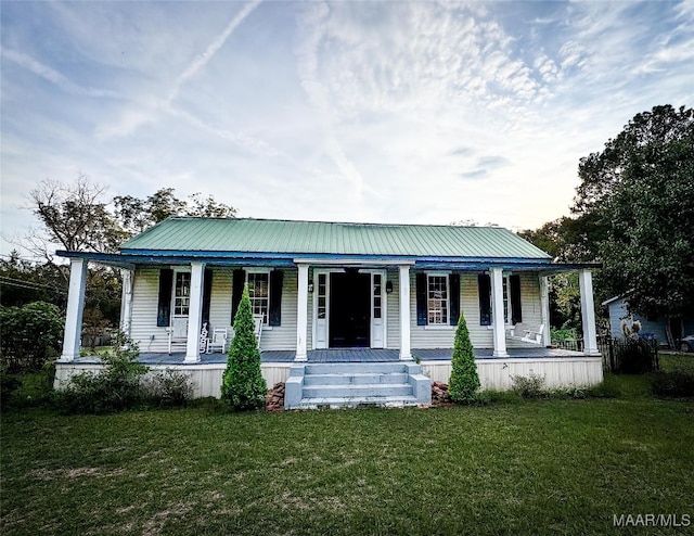 farmhouse-style home with a front yard and covered porch