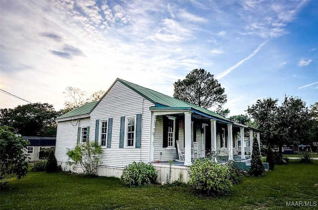 view of property exterior with a yard and covered porch