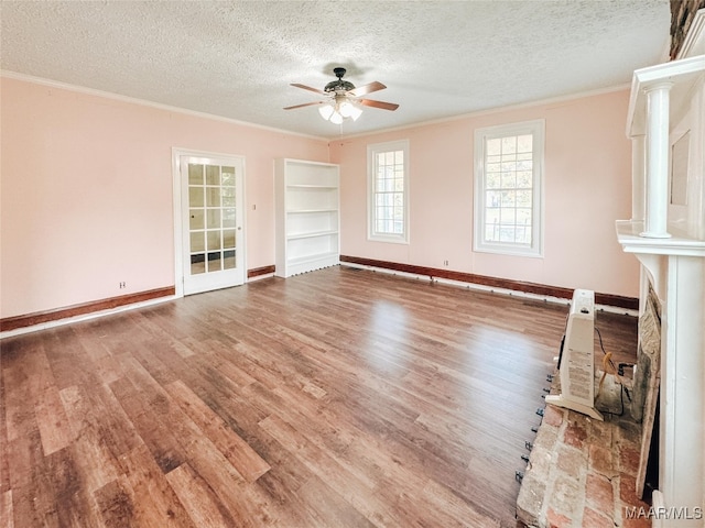 unfurnished living room featuring ceiling fan, hardwood / wood-style flooring, crown molding, and a textured ceiling