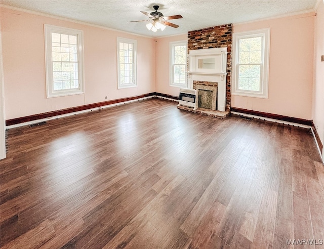 unfurnished living room featuring a healthy amount of sunlight, hardwood / wood-style floors, and a textured ceiling