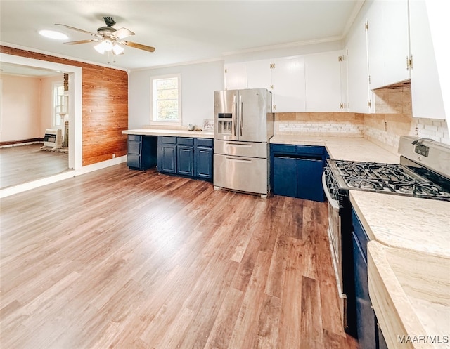 kitchen with blue cabinets, tasteful backsplash, white cabinetry, appliances with stainless steel finishes, and light hardwood / wood-style floors