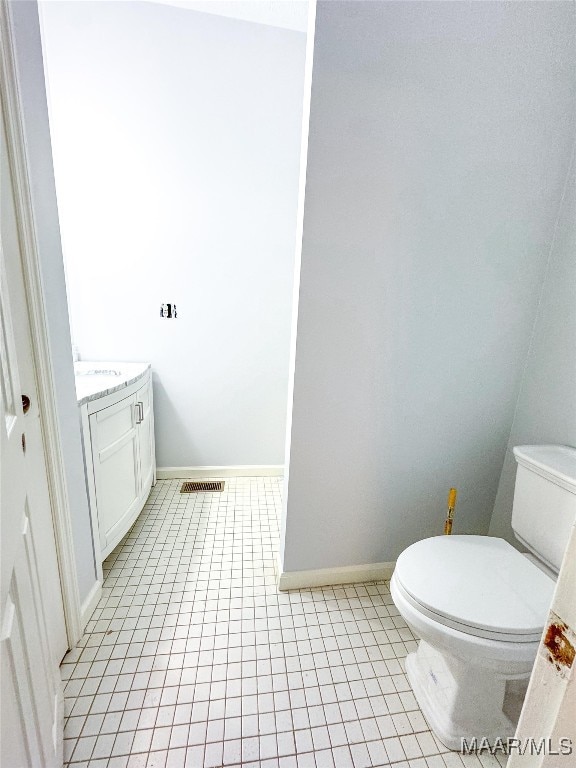 bathroom with tile patterned floors, vanity, and toilet