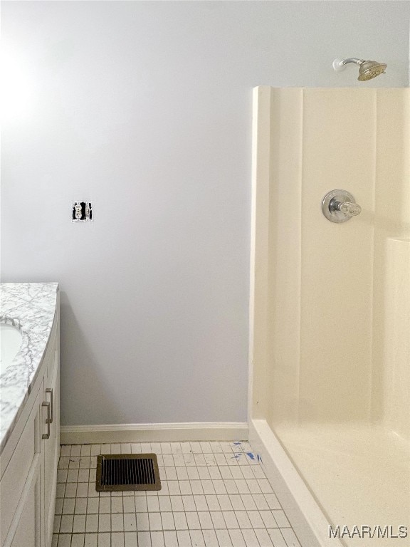 bathroom featuring tile patterned floors, walk in shower, and vanity