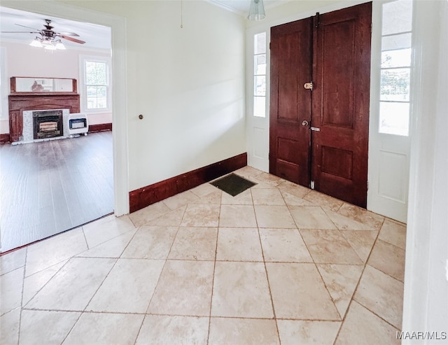 foyer with a barn door, light hardwood / wood-style floors, ornamental molding, and ceiling fan