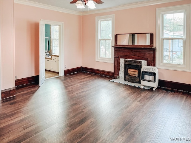 unfurnished living room with ceiling fan, ornamental molding, heating unit, dark wood-type flooring, and a fireplace