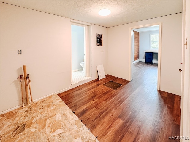 spare room featuring a textured ceiling and hardwood / wood-style flooring