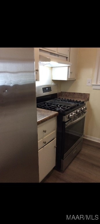 kitchen with white cabinets, stainless steel appliances, and dark wood-type flooring