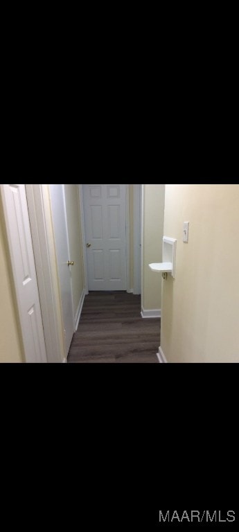 corridor with dark hardwood / wood-style flooring