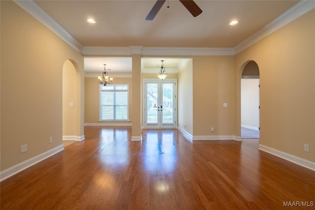 spare room with french doors, ceiling fan with notable chandelier, crown molding, and hardwood / wood-style floors