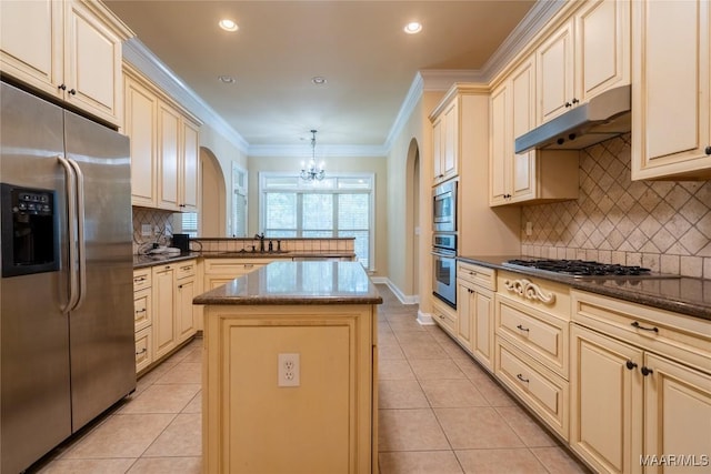 kitchen with kitchen peninsula, appliances with stainless steel finishes, sink, pendant lighting, and a kitchen island