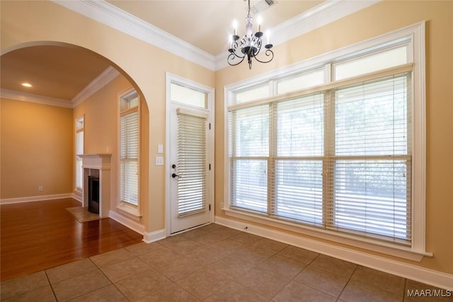 interior space featuring tile patterned flooring, ornamental molding, and an inviting chandelier