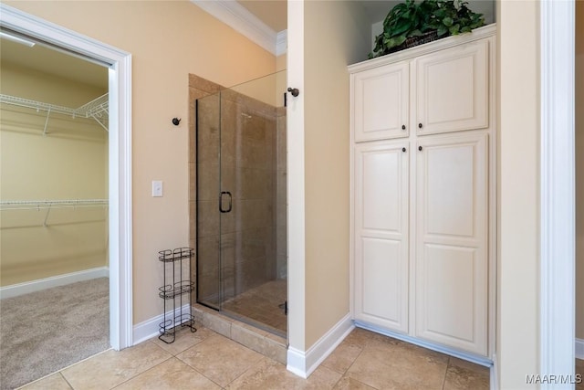 bathroom with walk in shower, tile patterned flooring, and ornamental molding