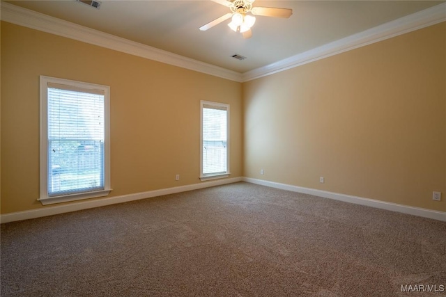 carpeted spare room with ceiling fan, crown molding, and a wealth of natural light