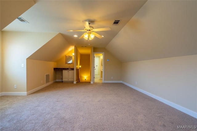 additional living space featuring light carpet, ceiling fan, and lofted ceiling