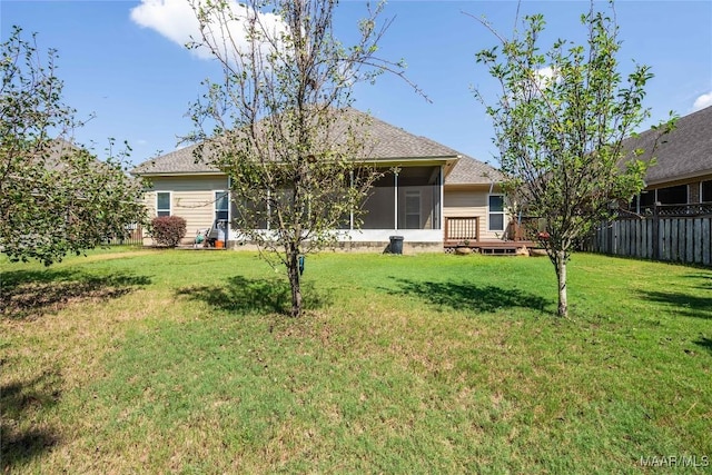 back of house featuring a lawn, a sunroom, and a deck