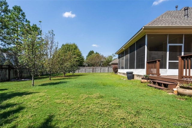 view of yard featuring a sunroom and a wooden deck