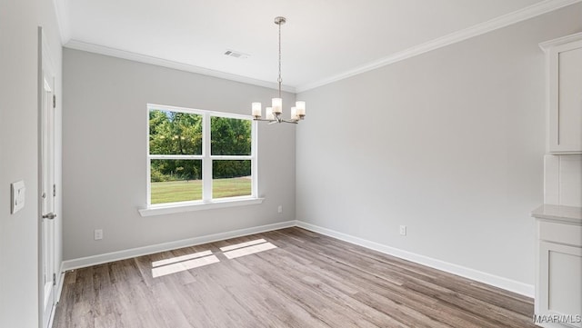 unfurnished dining area with a chandelier, light hardwood / wood-style floors, and crown molding