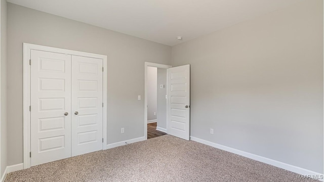 unfurnished bedroom featuring a closet and dark colored carpet