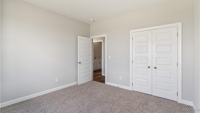 unfurnished bedroom featuring a closet and dark carpet