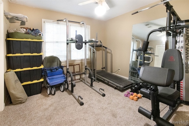 workout room with ceiling fan and light colored carpet