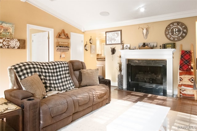 living room with a high end fireplace, vaulted ceiling, hardwood / wood-style floors, and crown molding