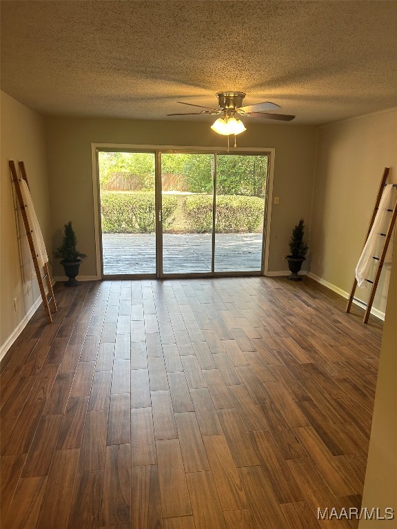 spare room featuring ceiling fan, dark hardwood / wood-style floors, and a healthy amount of sunlight