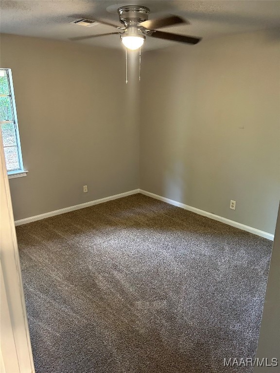 unfurnished room with carpet, ceiling fan, and a textured ceiling