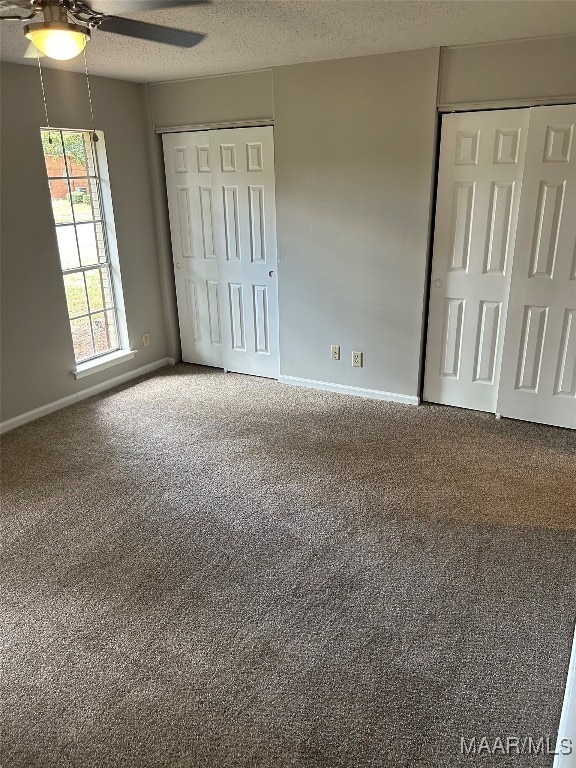 unfurnished bedroom featuring a textured ceiling, carpet floors, and ceiling fan