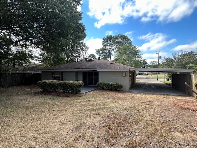 back of house featuring a carport and a yard