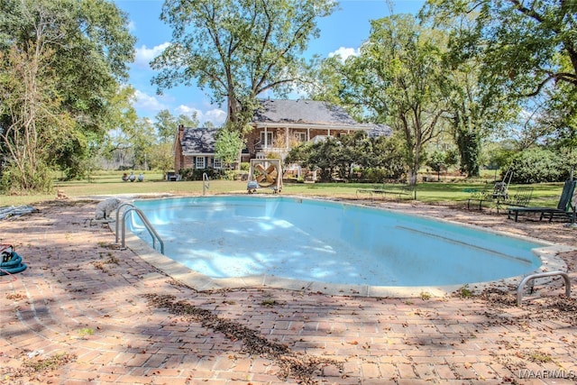 view of swimming pool with a yard and a patio