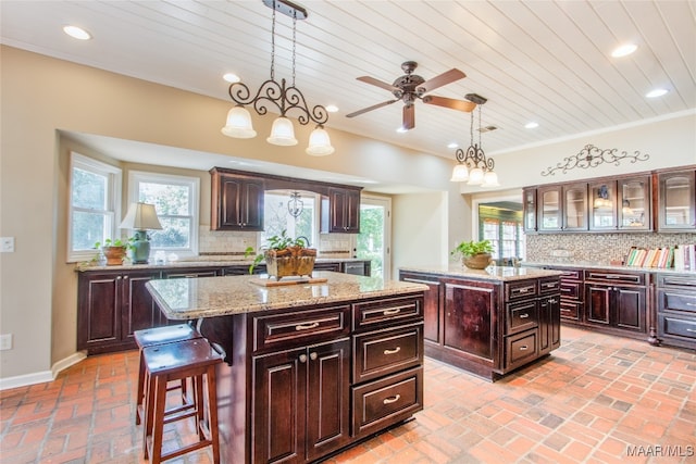 kitchen featuring backsplash, dark brown cabinetry, and a center island