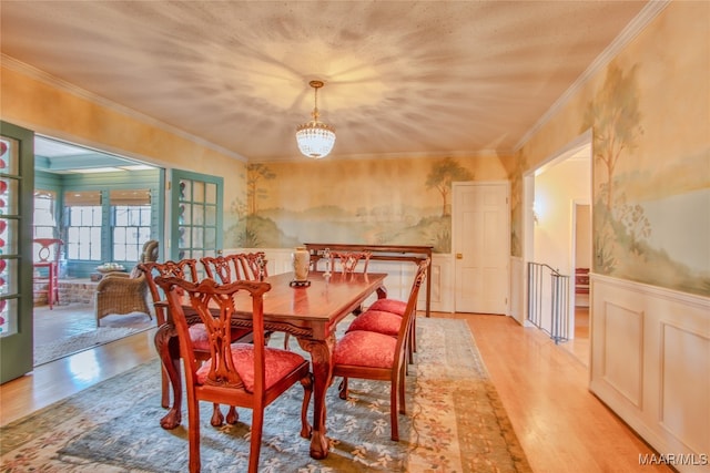 dining space featuring an inviting chandelier, light hardwood / wood-style flooring, and ornamental molding