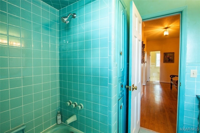 bathroom featuring tiled shower / bath combo and hardwood / wood-style floors