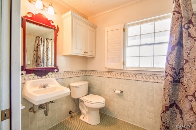 bathroom with tile walls, a textured ceiling, toilet, sink, and tile patterned floors