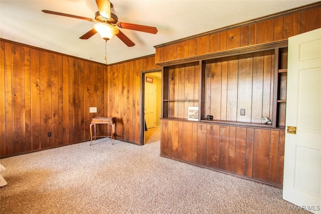 601 N Pickett St, Autaugaville, AL 36003 - spare room with crown molding, wood walls, carpet flooring, and a ceiling fan