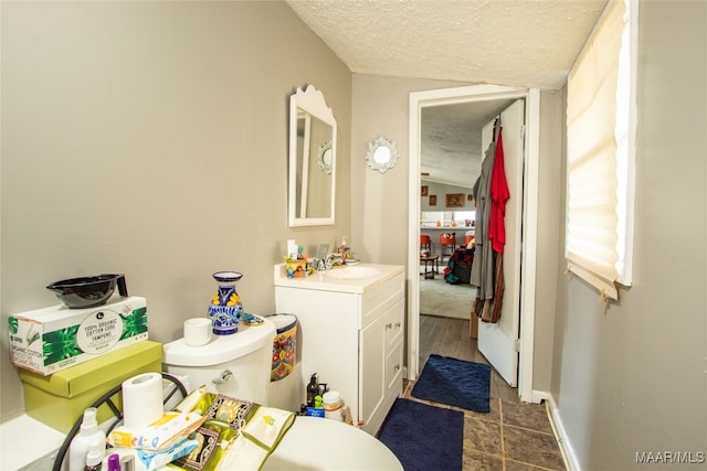 bathroom featuring vanity, toilet, and a textured ceiling