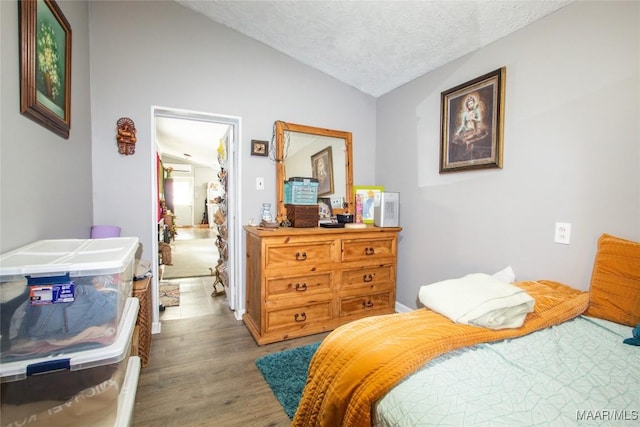 601 N Pickett St, Autaugaville, AL 36003 - bedroom with a textured ceiling, wood finished floors, and vaulted ceiling